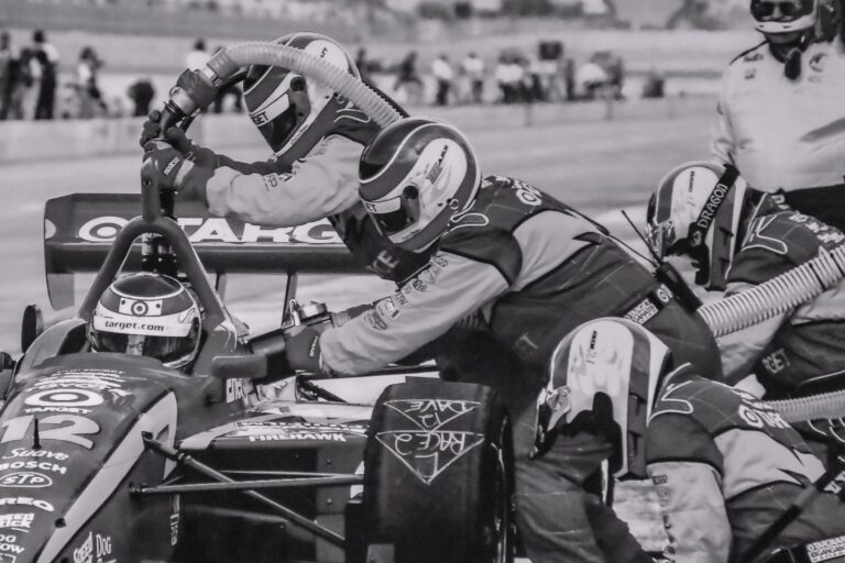 Pit crew members working in sync on a race car during a pitstop