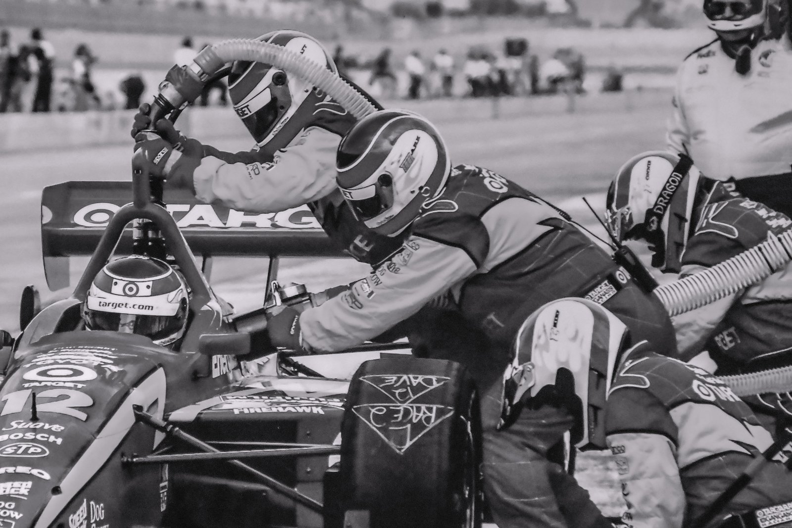 Pit crew members working in sync on a race car during a pitstop